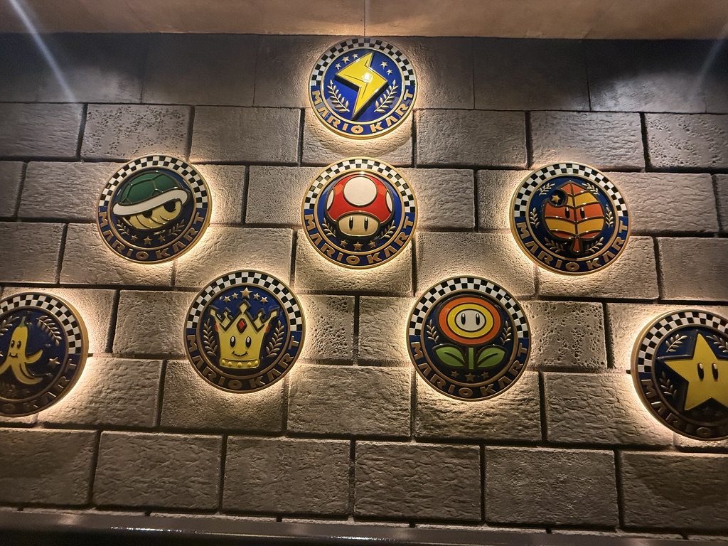 Mario Kart badges on a stone wall